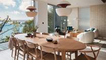 A grand Skovby dining table is positioned in the centre of the room, with original Hans Wegner chairs to seat twelve