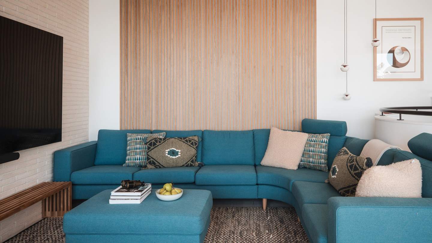 At the far side of the room, uncover the calming lounge, with an acoustic, oak-slatted feature wall and ceiling