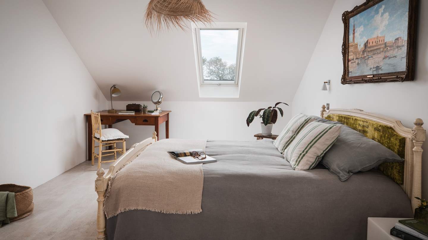 Taking centre stage is an antique French bed with a Carolyn Quartermaine note sheet print headboard 