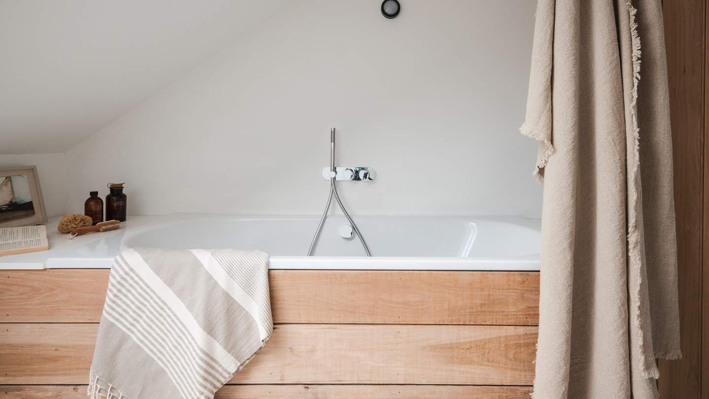 This bathroom is complete with a bathtub with a separate showerhead