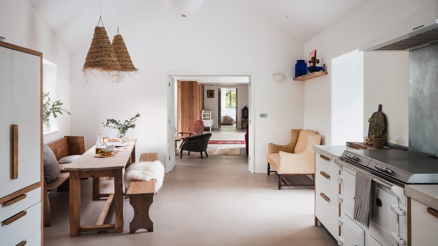 In the kitchen, bespoke wooden cabinets are paired with natural textiles in a symphony of soft tones