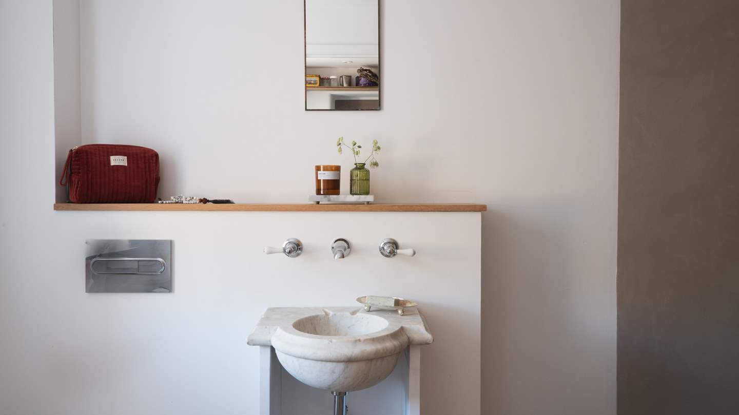 There is an additional bathroom with a vintage Carrara marble basin and rainfall shower can be found 