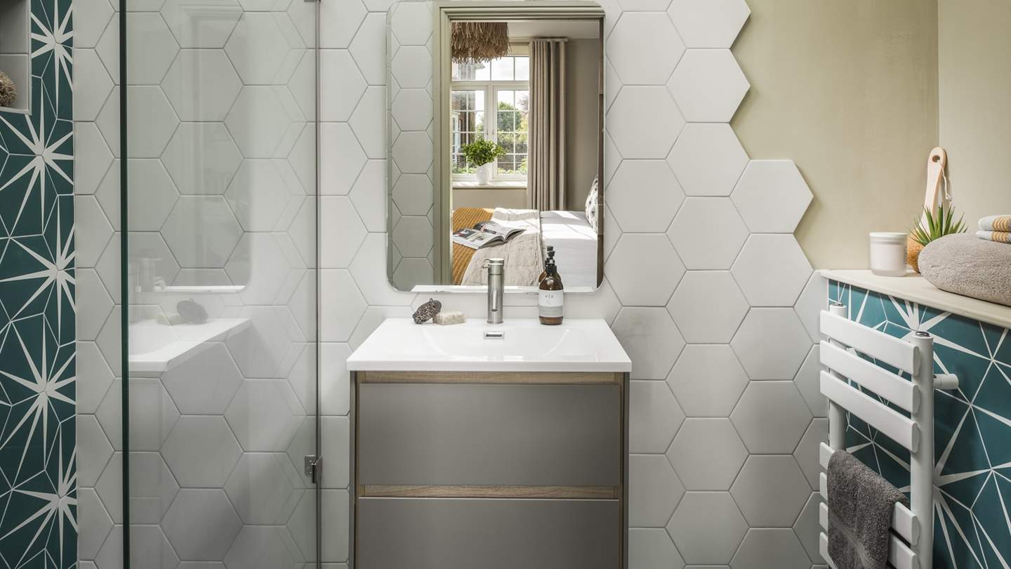 For added luxury and privacy, this bedroom is complete with an ensuite bathroom with attractive geometric tiling and a rainfall shower