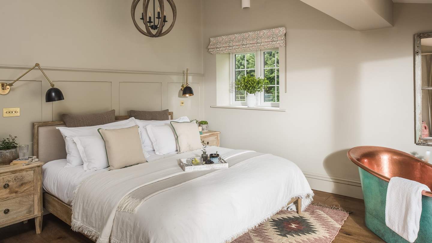 The master bedroom, a light and dreamy haven, features a super-king bed topped with the cosiest throws and pillows
