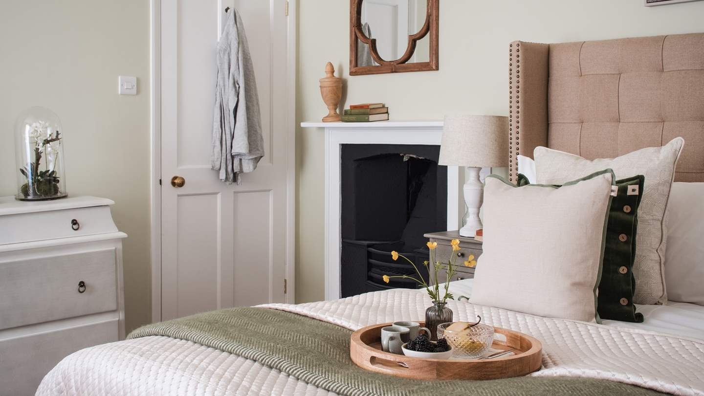 A period fireplace adds eye-catching detail to this soothing space