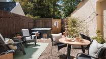 For alfresco meals and moments in the sunshine, it features a table and chairs, as well as two Adirondack lounger chairs adorned with throws