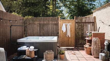 For soaks under starry skies, a private outdoor hot tub resides in the corner, illuminated by fairylights...