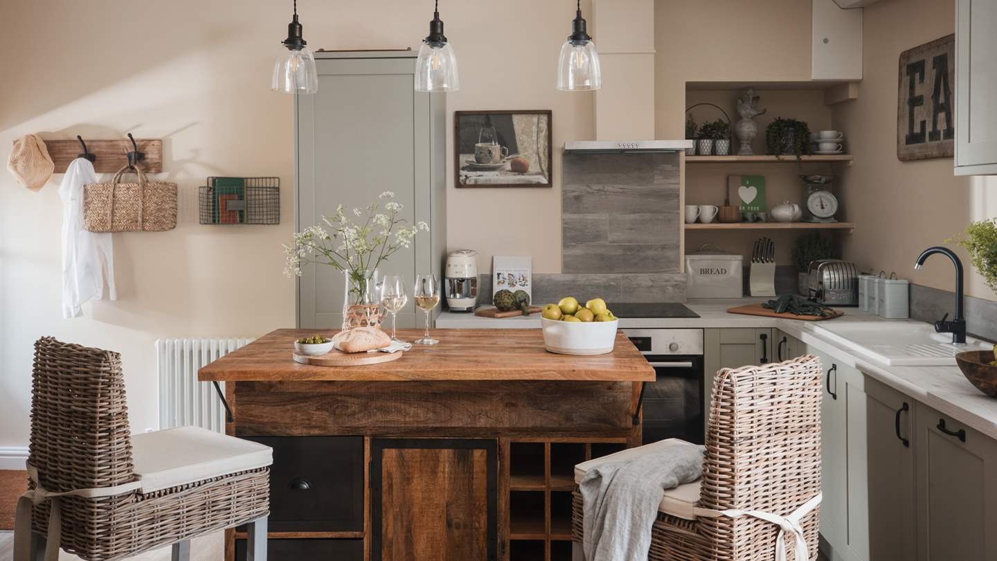 The dreamy kitchen features sage green units, paired with attractive open shelves and stylish lighting... 