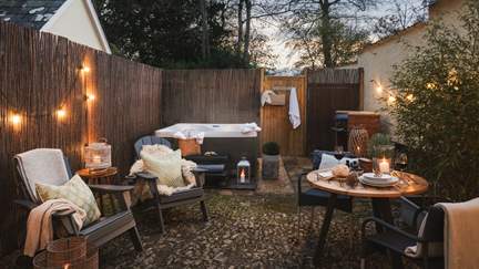 For soaks under starry skies, a private outdoor hot tub resides in the corner, illuminated by fairylights...