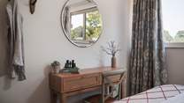 At the foot of the bed, you will find a rustic dressing table, which also makes for a fantastic desk space should you need to catch up on an email or two during your stay
