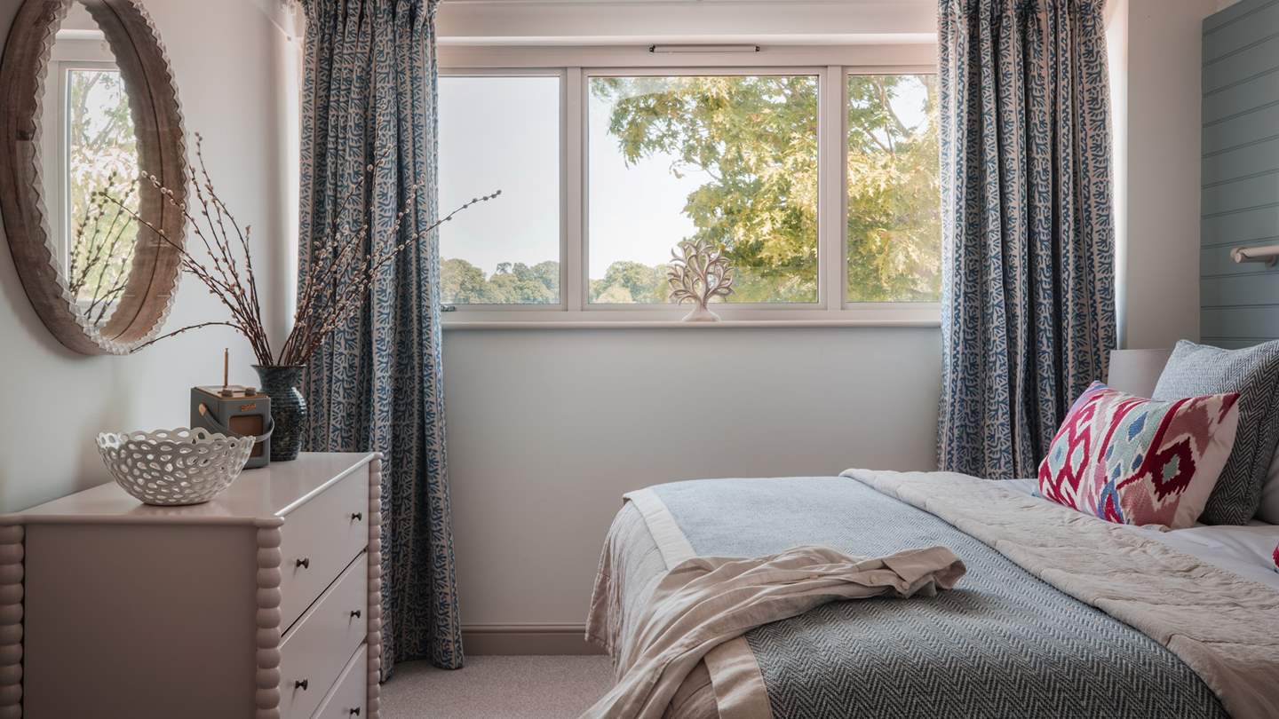 You’ll find plenty of space for storing your belongings, with an open wardrobe and hanging space, plus there’s a sweet dressing table with a quirky mirror for pampering moments