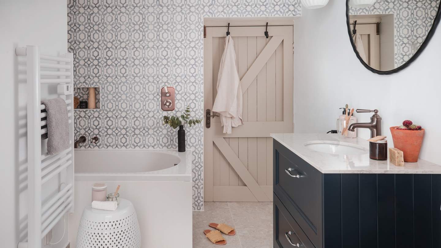 Adjoining the bedroom is the beautifully tiled bathroom in folk-art designed patterns, complete with a smartly tucked away bath and ceiling mounted shower