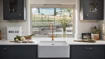 Sleek green cupboards, Carrara Quarts worktops and beautiful brass detailing ooze luxury, offering the perfect setting for creating culinary masterpieces
