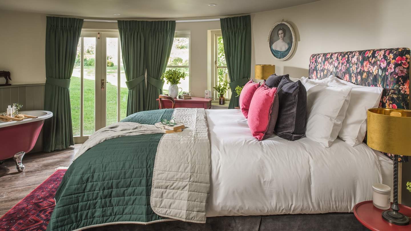 Downstairs, the second bedroom also boasts its own roll top bathtub, this time in a magnificent red, which parallels the other finishing touches found throughout the room