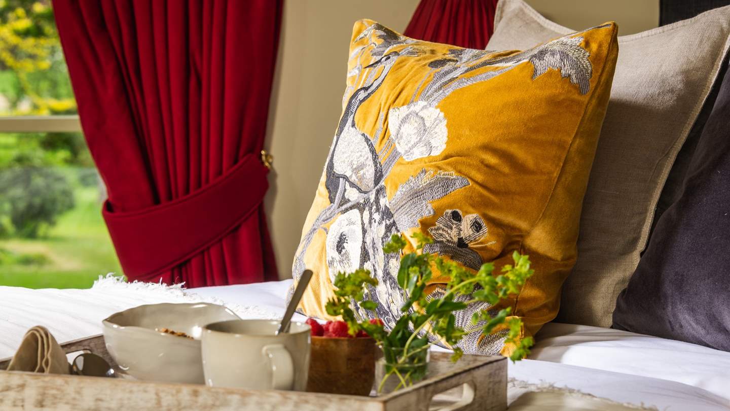 The dreamy super king bed draws the eye with plush pillows and a towering headboard