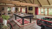 Upstairs, vaulted ceilings and rich tones set the scene for the entertaining games room