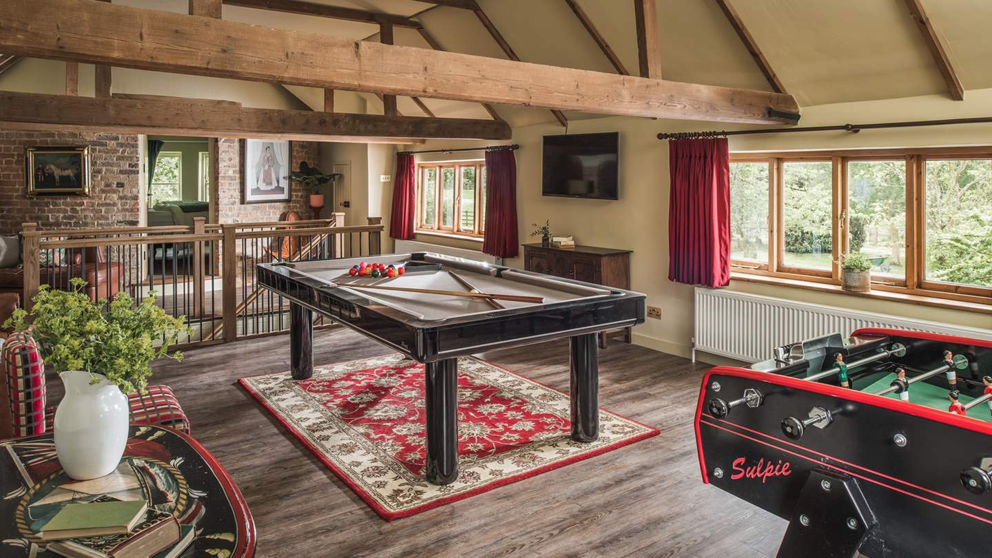 Upstairs, vaulted ceilings and rich tones set the scene for the entertaining games room