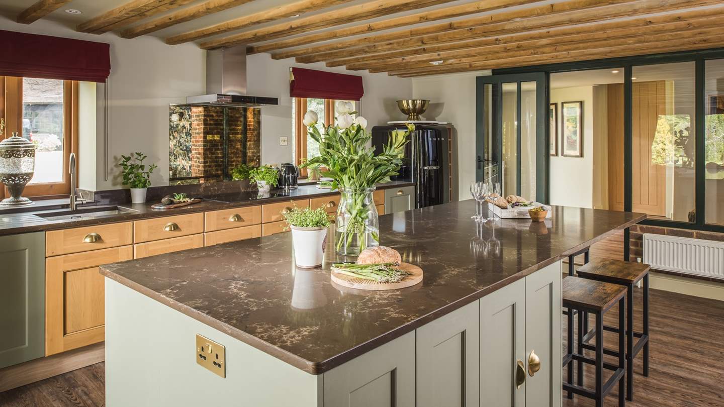 At the opposite end of the beam-topped room, a modern kitchen awaits