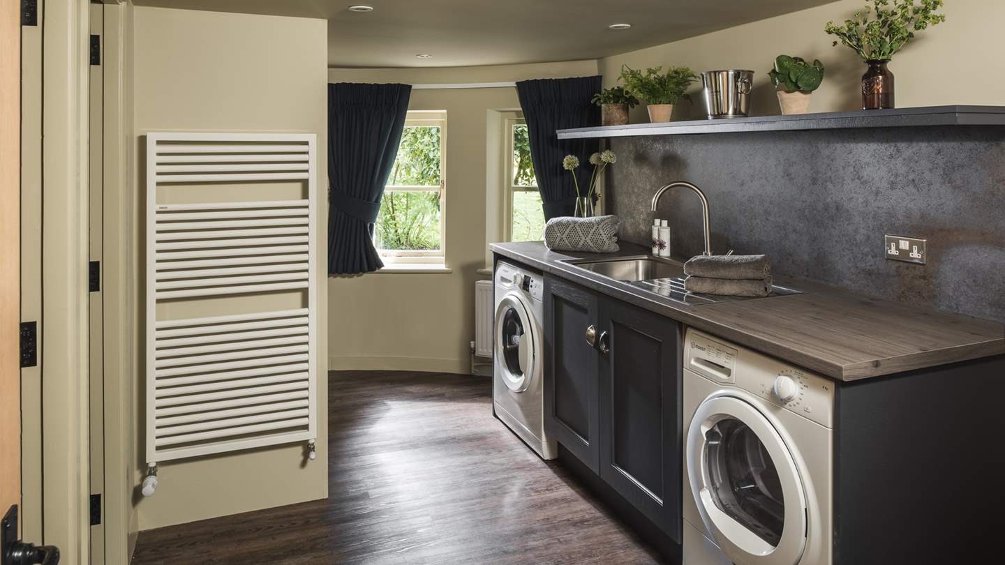 Opposite the oh-so-welcoming living area, you’ll find a sleek utility room, complete with a sink, washing machine, tumble dryer and space for all your coats and boots, as well as a downstairs water closet