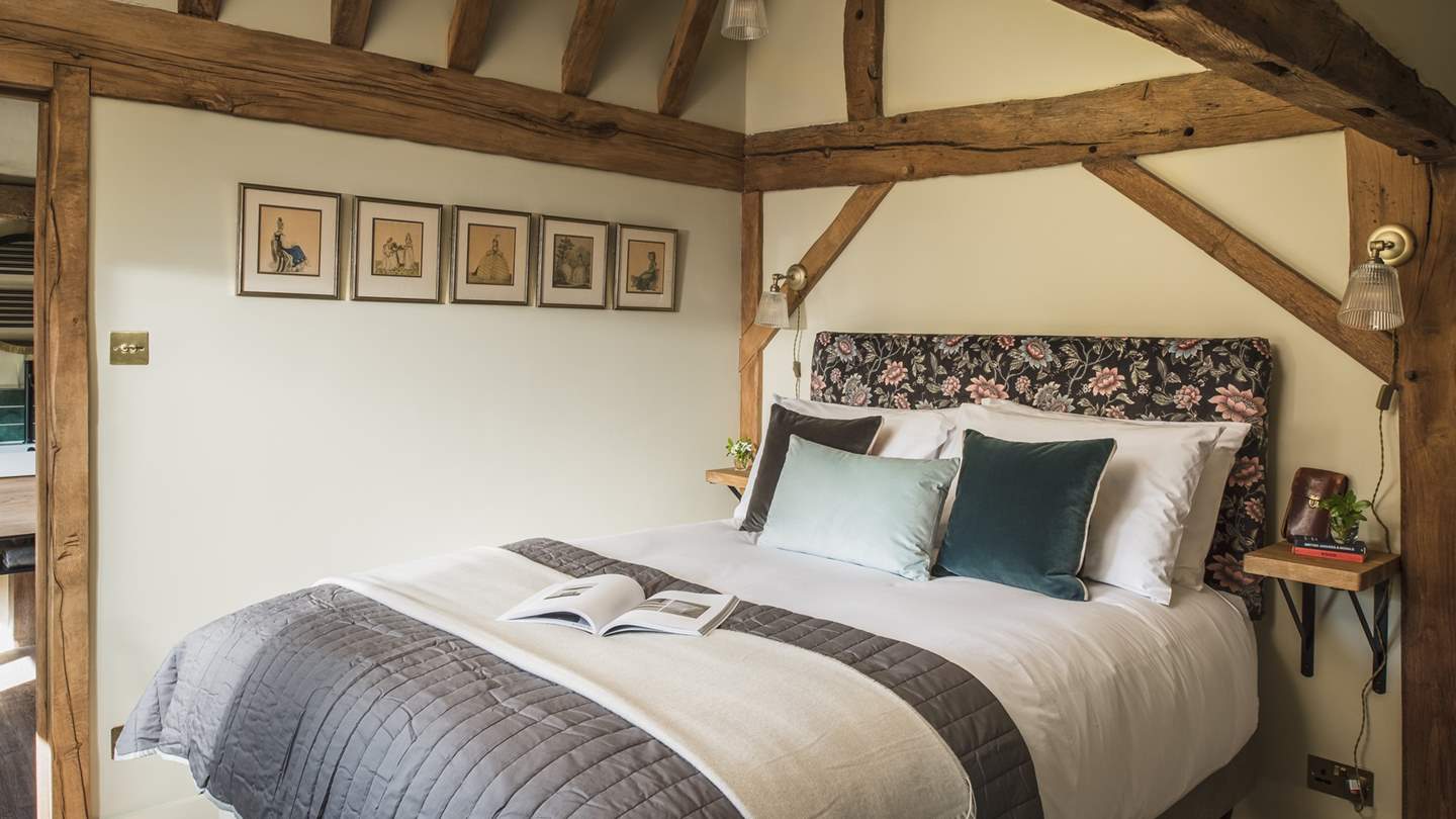 Bedroom five features traditional exposed beams and sumptuous earth tones across the king size bed