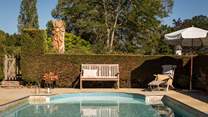 A medley of outdoor seating and loungers surround the swimming pool