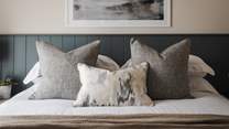 Tranquil tones adorn the walls, complemented by slate-coloured wainscoting and textured throws