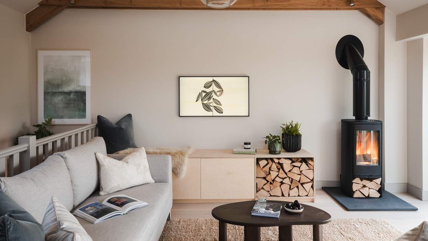 The lounge presents a bespoke sectional sofa, designed around a coffee table and warming wood burning stove