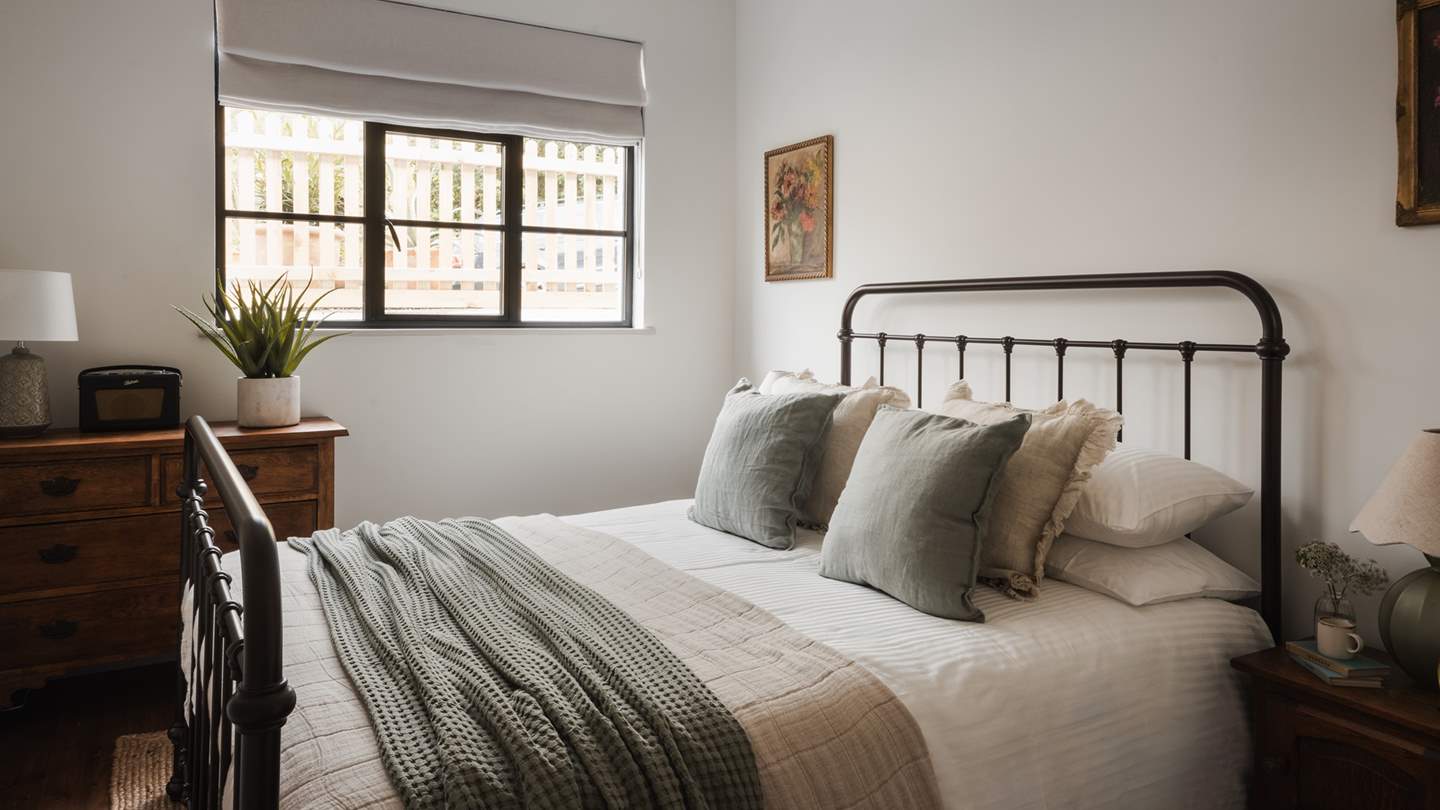 Dressed in sage green and cream hues with floral artwork, is the first king-sized bedroom,  which is nestled on the ground floor