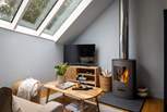 The modern wood burning stove creates a snug and inviting space in the colder months