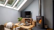 The modern wood burning stove creates a snug and inviting space in the colder months
