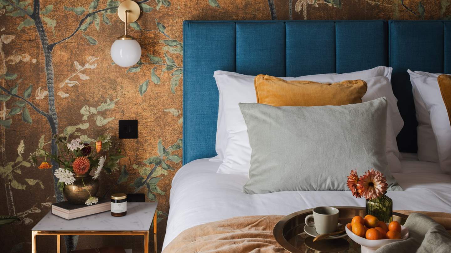 Woodland-esque wallpaper and vaulted beams ensure this space is a sanctuary for serene slumbers