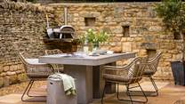 Savour alfresco feasts around the sleek dining table, with an Ooni pizza oven and a charcoal barbeque which doubles up as a firepit 