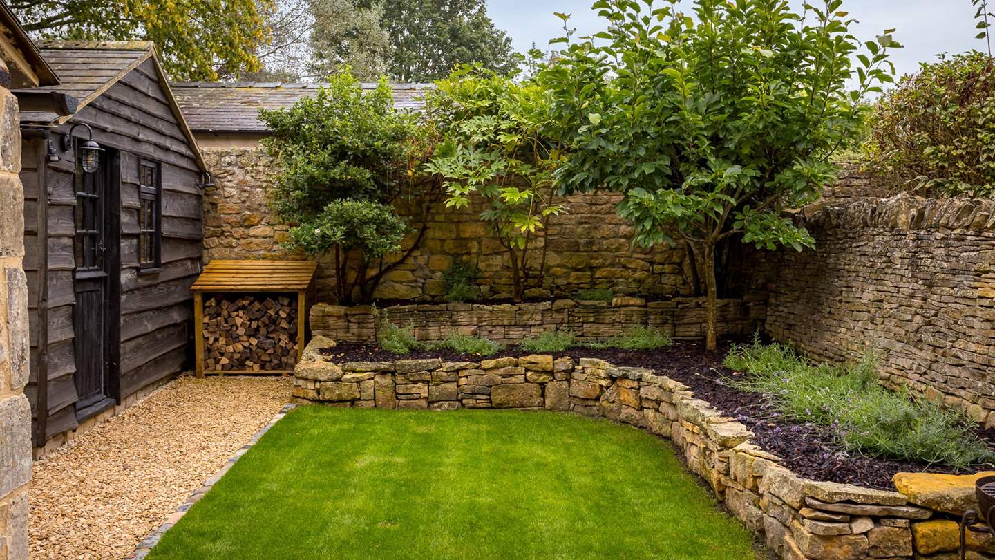 The Honeypot's garden promises a tranquil space with manicured greenery, a paved patio, and verdant lawn