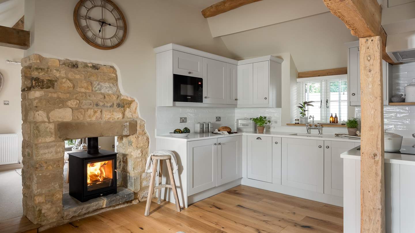 Pockets of exposed Cotswold stone continue into the kitchen, pairing beautifully with pearly white worktops and calming neutral cupboards