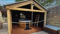 For soothing dips at dusk, a wood-fired hot tub is nestled beneath a walled canopy for the utmost privacy