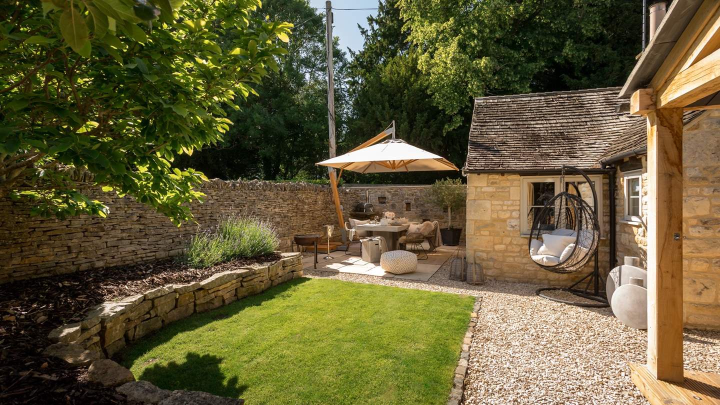 The Honeypot's garden promises a tranquil space with manicured greenery, a paved patio, and verdant lawn