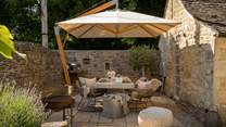 A sleek dining table with rattan chairs for four is perfectly positioned to bask in the sun on balmy summer days, savouring alfresco feasts with your special someone