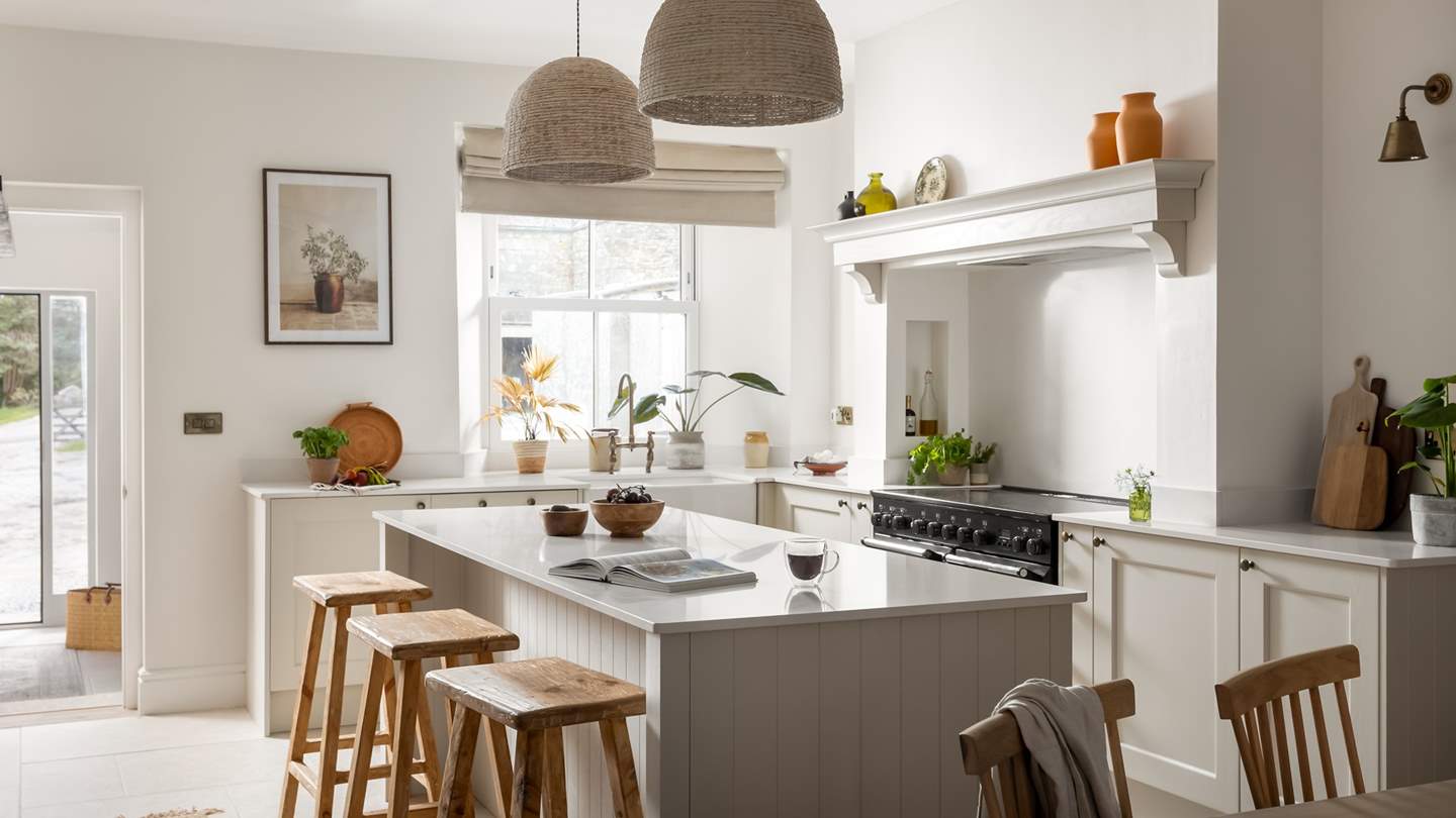 Delicately neutral tones sweep through the kitchen, accented with earthy jars and warm woods to create an open and welcoming space

