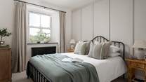 Bedroom two continues the harmonious hues with a gentle mix of soft greens and dove greys