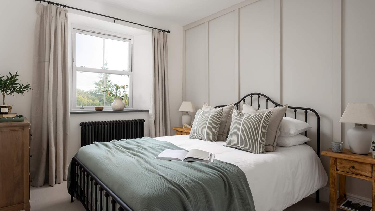 Bedroom two continues the harmonious hues with a gentle mix of soft greens and dove greys
