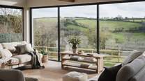 As soon as you step into the living room, your eyes drift to the incredible floor to ceiling windows that look out across a patchwork of Cornish fields