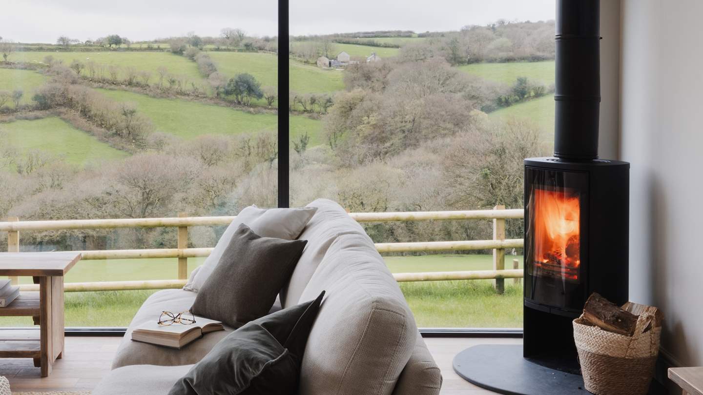 A flickering wood burning stove sits in the corner casting a rosy glow over the room
