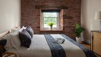 The second bedroom is equally romantic with rustic beams and a red-brick feature wall