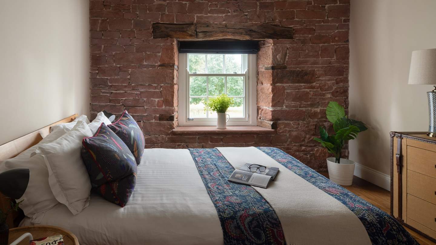The second bedroom is equally romantic with rustic beams and a red-brick feature wall