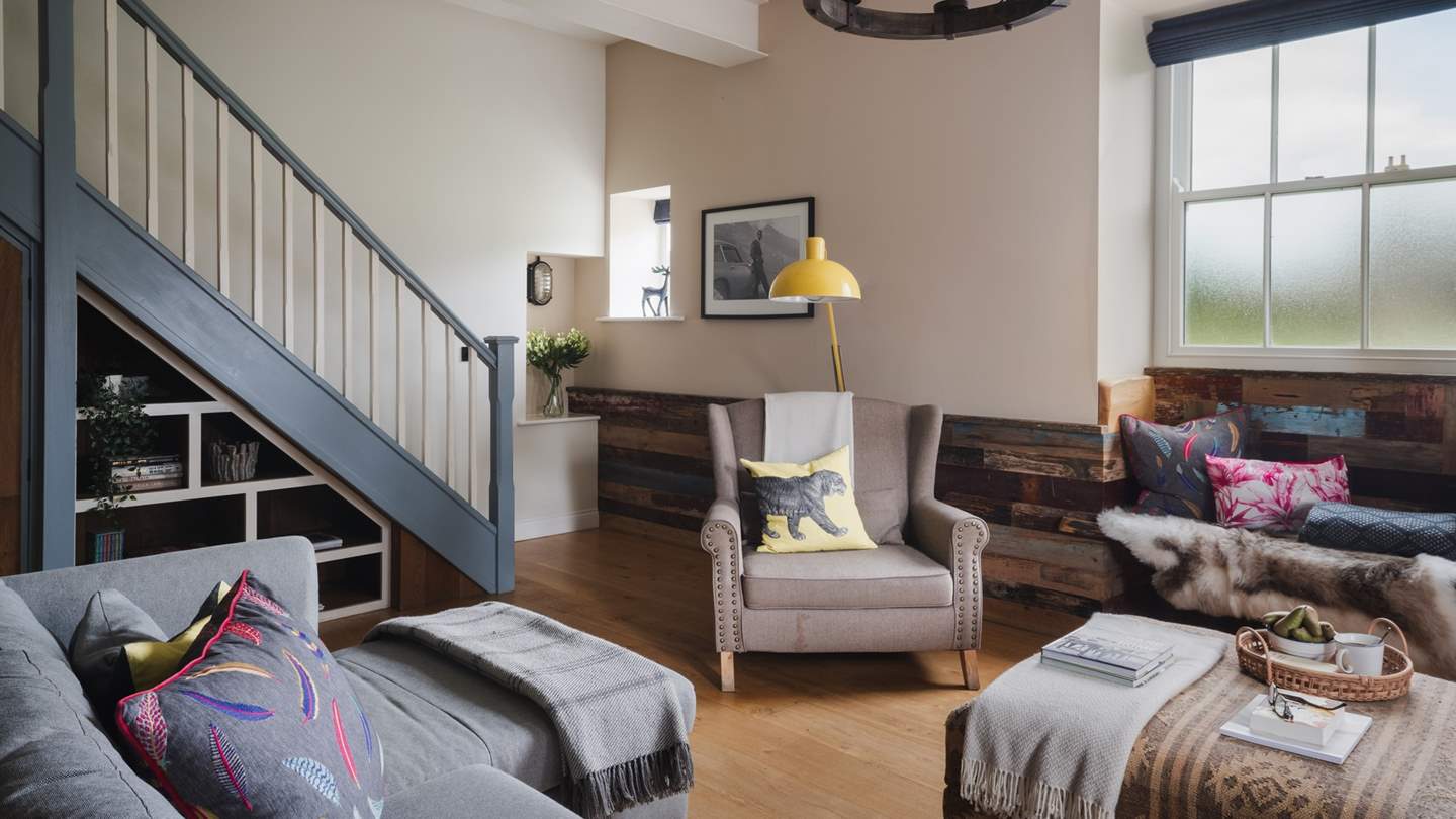 A large, charcoal grey corner sofa and a snug armchair offer the cosiest of spots to indulge in your favourite box set on the Smart TV with Netflix