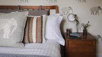 A double bed and bedside tables beautifully complement the mid-century style headboard
