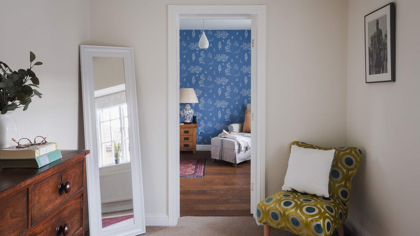 Storage can be found in the walk-through, complete with a chest of drawers, free standing mirror, and an accent chair