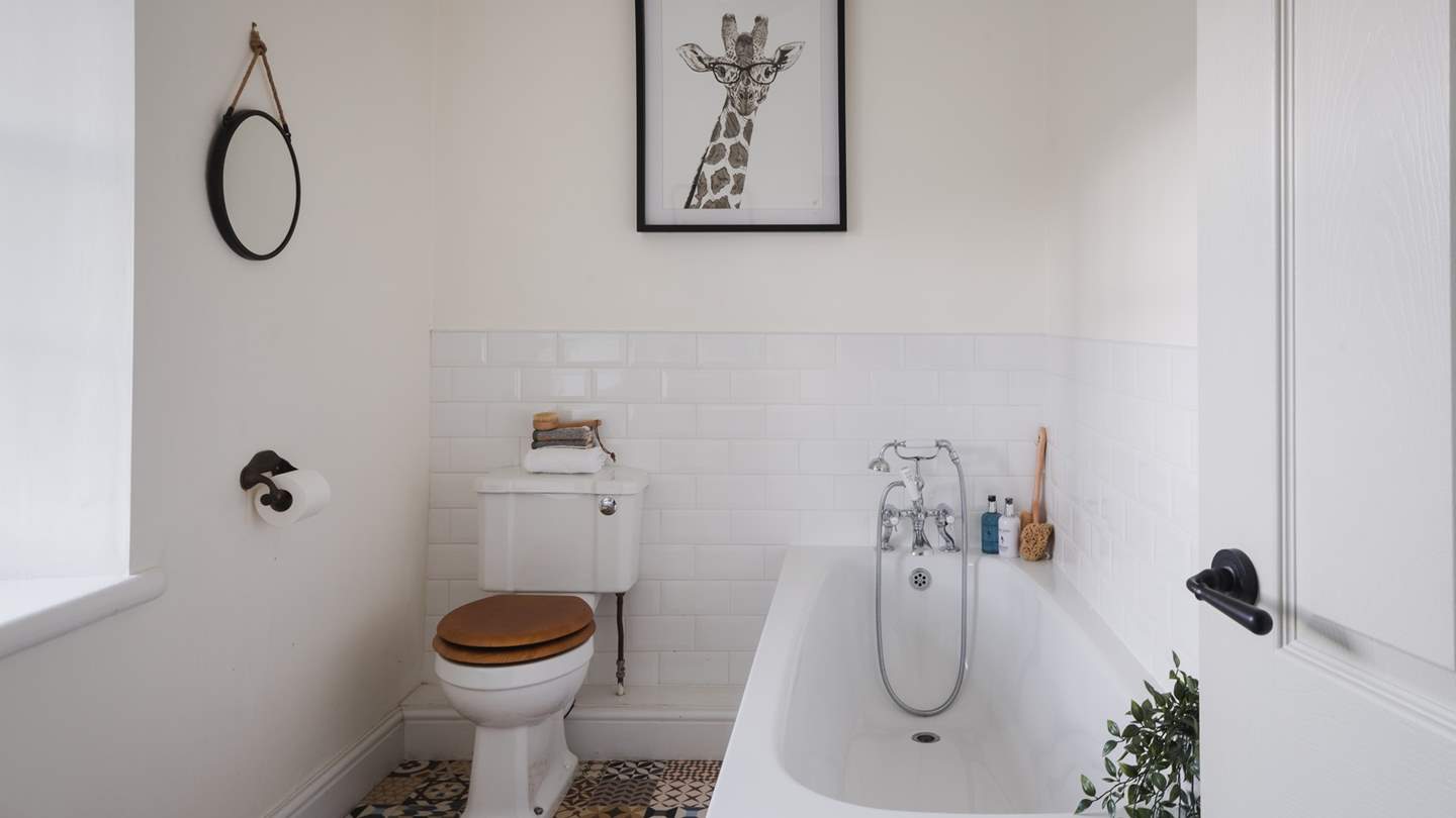 The modern family bathroom is situated on the first floor, complete with a sleek white bathtub and a handheld shower attachment for serene soaks
