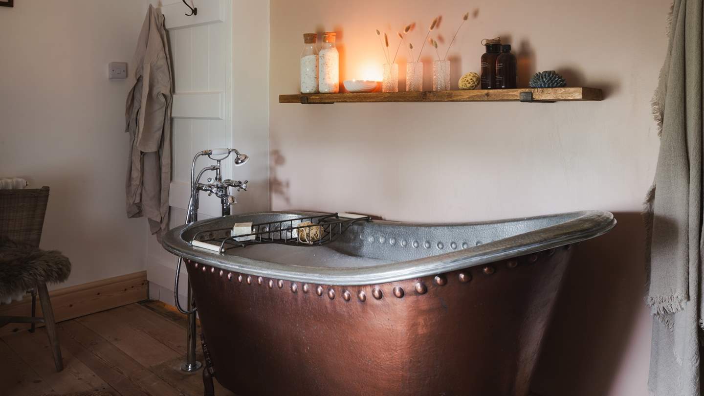 Next door is the captivating family bathroom, a dream in calming pinks and creams with oak accents. 