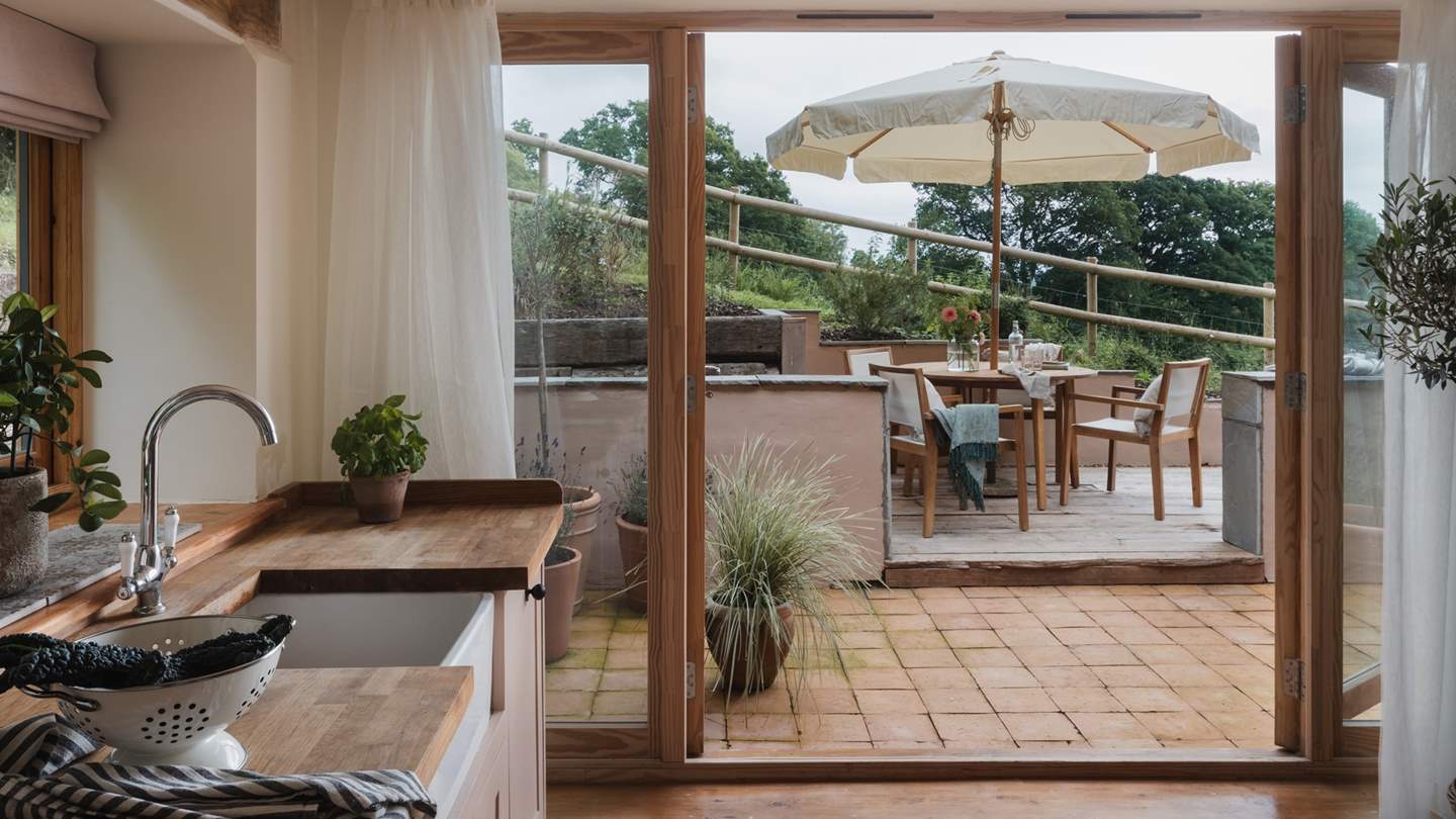 Behind delicately dancing voiles, double doors open out to the sun-soaked patio, where a wooden table for four awaits for summer soirees...